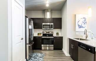 Kitchen with island, farm-style sink, wood-plank flooring, and pantry