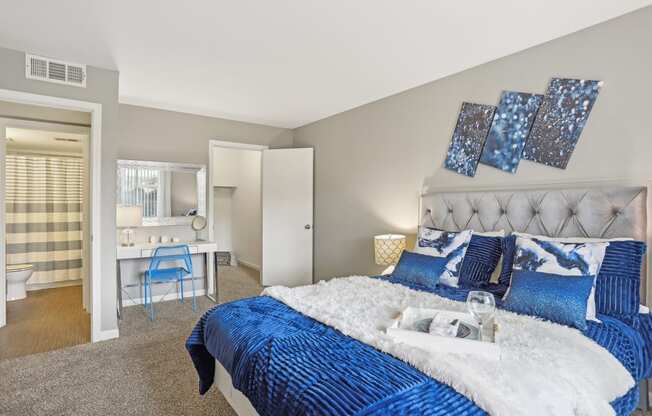 a blue and white bedroom with a large bed and a bathroom