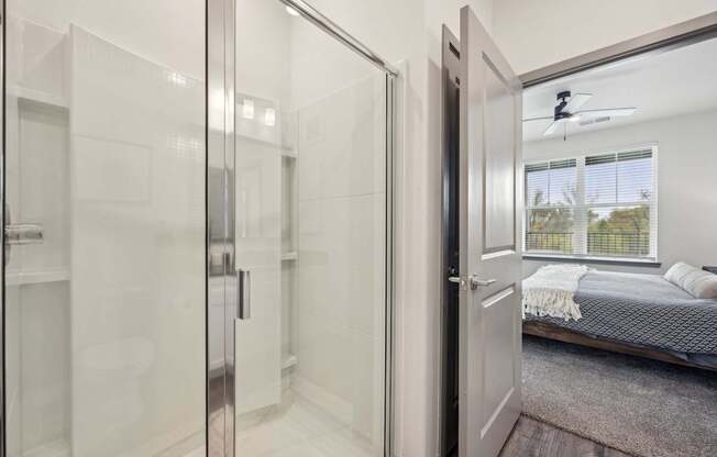 a bedroom with a bed and a glass closet at The Quarry Luxury Apartment Homes, Fort Collins, 80526
