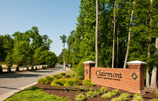 Tree-lined street with Clairmont Apartments sign leading into the community