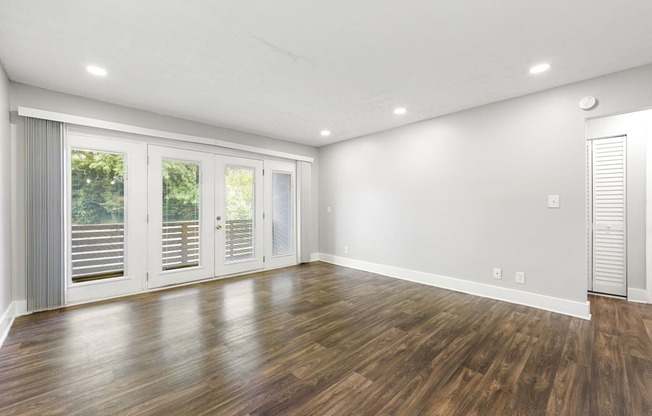 Living room with updated flooring and private patio at Balfour Chastain, Sandy Springs, GA