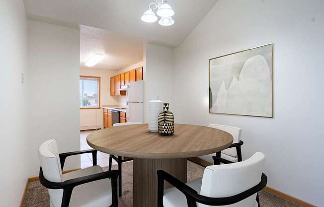 A dining room with a round table and chairs. Fargo, ND Summit Point Apartments