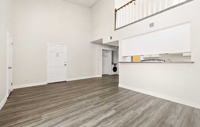 the living room and kitchen of a house with wood flooring