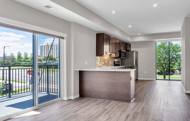 A modern kitchen with a wooden island and a view of the outdoors through the sliding glass doors.
