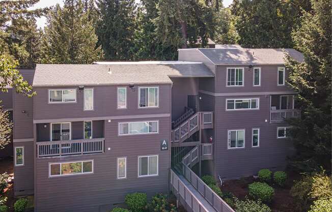 A large two-story house with a balcony and a staircase leading to the second floor.