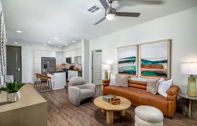 A living room with a brown couch, a wooden coffee table, and a painting on the wall.