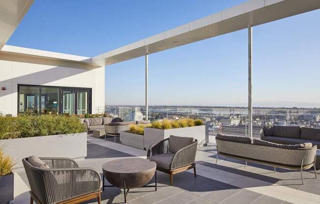 A patio with a table and chairs overlooking a cityscape.