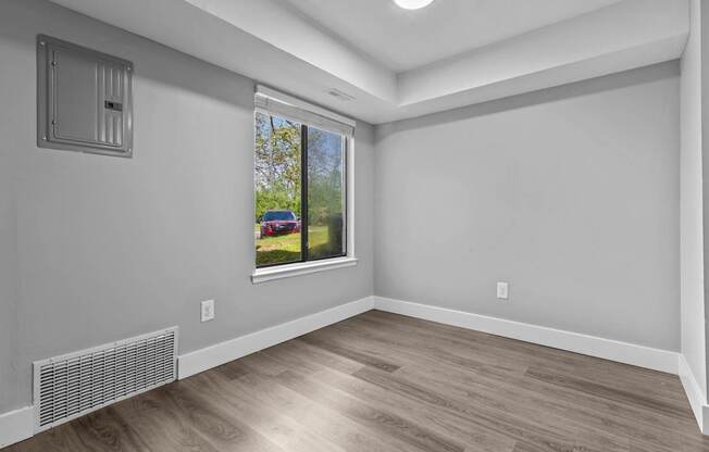 A room with a window showing a red car outside.