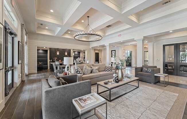 A modern living room with a grey sofa and a glass coffee table.