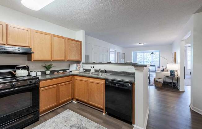 A kitchen with black appliances and wooden cabinets.