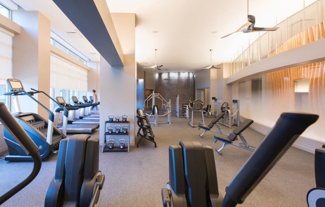 a room filled with lots of different types of exercise equipment at The Acadia at Metropolitan Park, Arlington