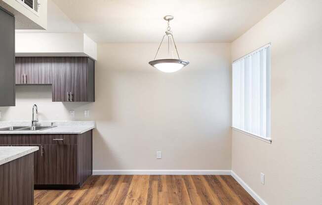 A kitchen with wooden floors and a white countertop.