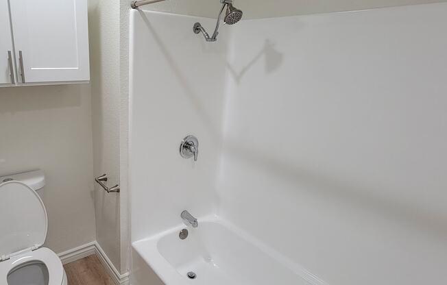 Bathroom with white fixtures and cabinets in one bedroom apartment at the Atrium Apartments in San Diego, CA.