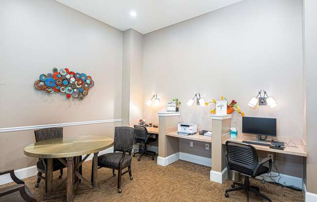 a conference room with a round table and a desk with a computer