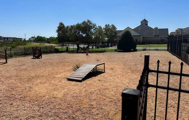 a park bench in the middle of a dirt field