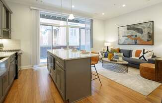 A modern kitchen with a large island and a view of the backyard.