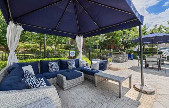 a patio with couches and umbrellas and tables