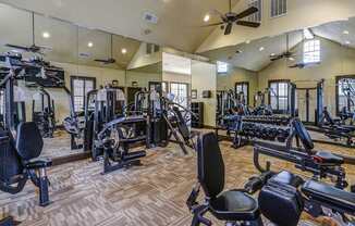 A spacious gym with a variety of equipment including treadmills, weights, and exercise machines.