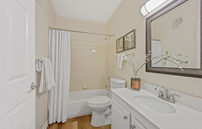 a bathroom with a white sink and toilet and a white shower curtain