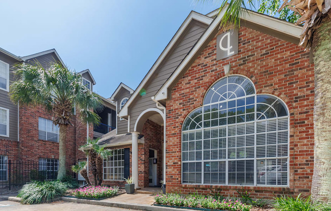 A brick building with a palm tree in front.