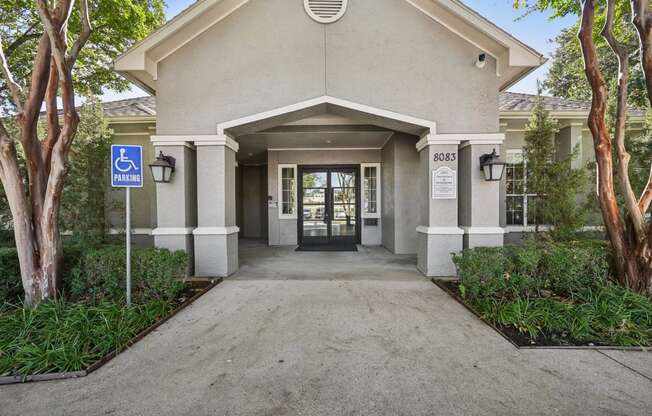 the entrance to a building with a walkway and trees