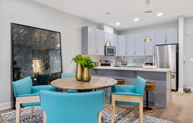 an open kitchen and dining room with blue chairs and a table