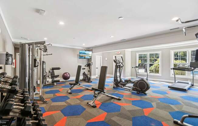 A gym with a variety of equipment including weights, a treadmill, and a stationary bike.
