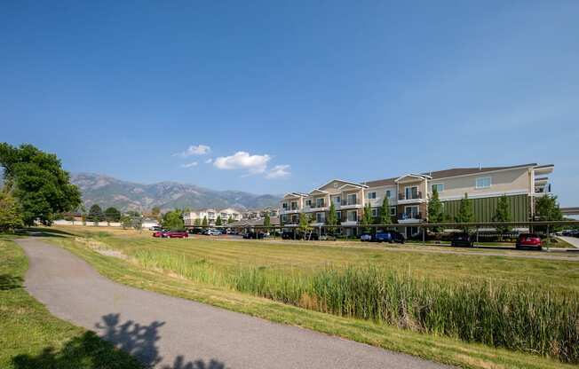 a pathway leading to a row of houses with mountains in the background