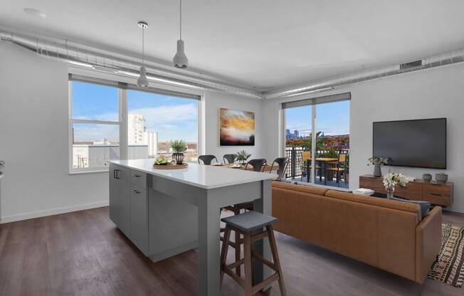 an open living room with a kitchen island and a living room