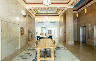 A long hallway with a blue carpet and a wooden table.
