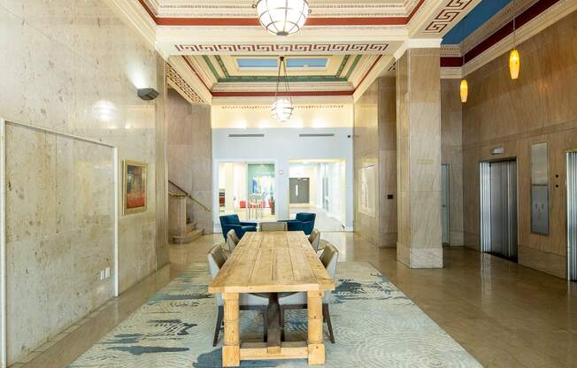 A long hallway with a blue carpet and a wooden table.