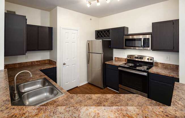 A classic style  kitchen with black cabinets  and stainless steel appliances