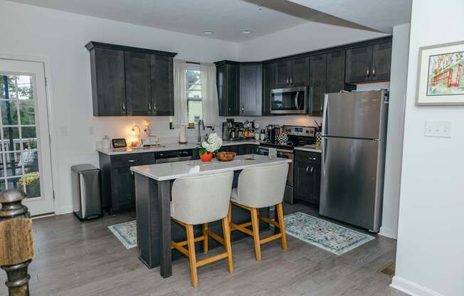 A kitchen with a table and chairs in the middle of it.