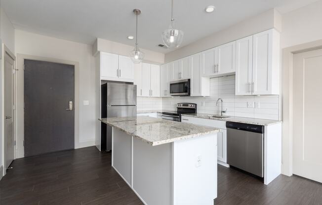 Hibernia kitchen with white cabinets, white tile backsplash, granite countertops and stainless steel appliances