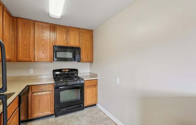 A kitchen with wooden cabinets and a black stove top oven.