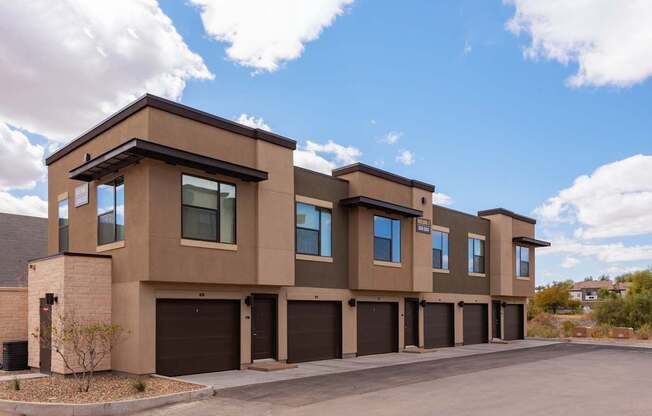 A row of modern townhouses with garages.