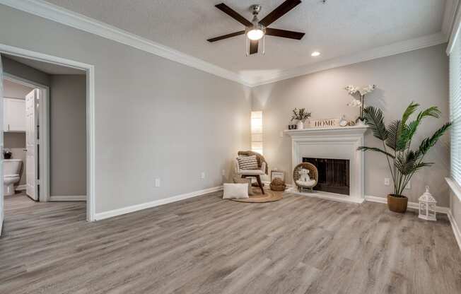 a living room with a fireplace and a ceiling fan