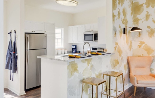 a kitchen with a marble counter top and a stainless steel refrigerator at Residences at Stevens Pond, Saugus, 01906