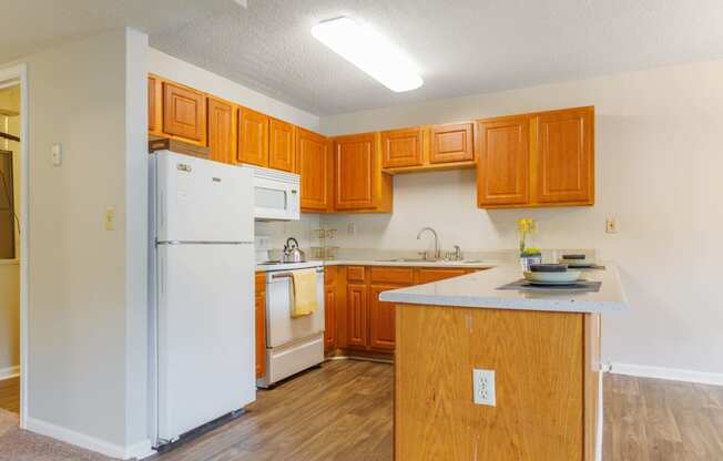 a kitchen with white appliances and wooden cabinets