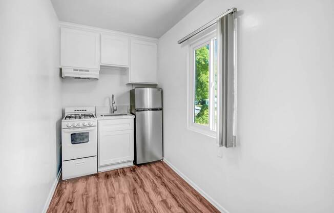 a kitchen with a stove refrigerator and a window