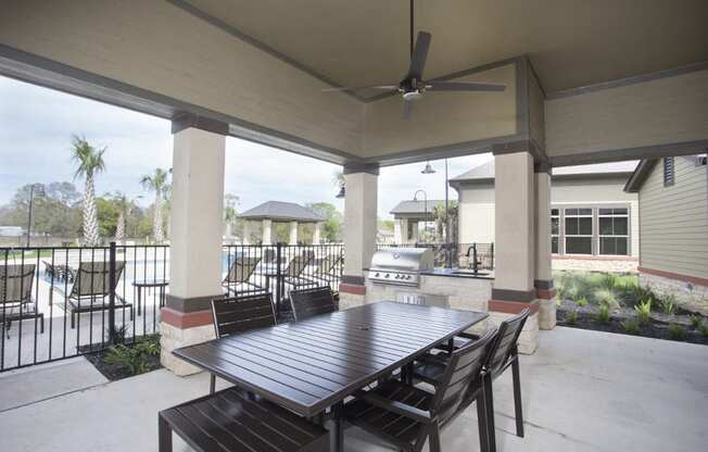 a patio with a table and chairs and a ceiling fan