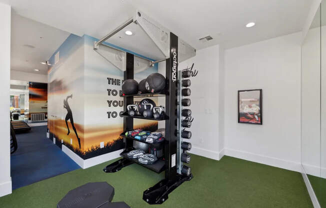 A gym room with a wall mural that says