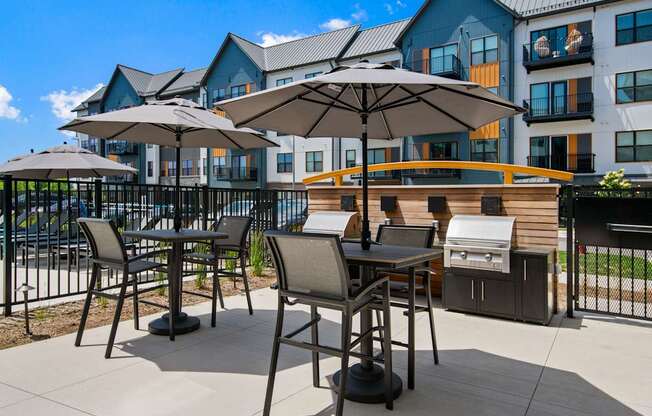 A patio with a table and chairs and umbrellas.