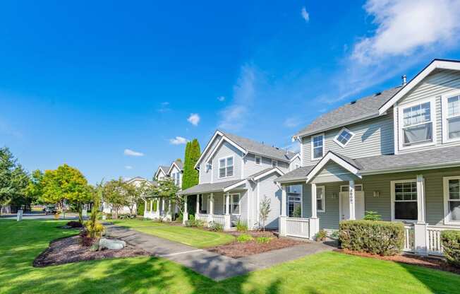 a row of houses with lawns and trees