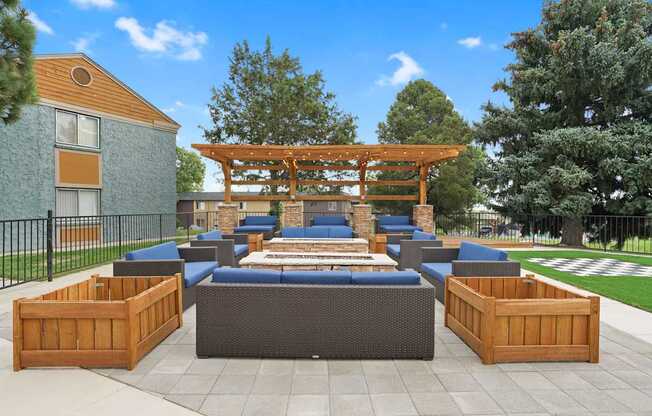 A wooden pergola is situated above a blue couch and a wooden table at Mountain Vista Apartments, Lakewood