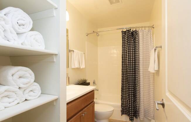 a bathroom with white towels and a shower and a sink