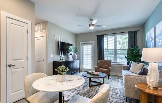 A living room with a white table and chairs.