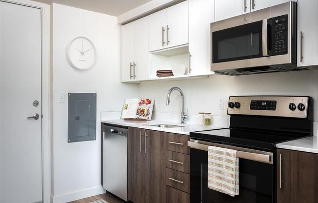 a kitchen with white cabinets and black appliances and a microwave