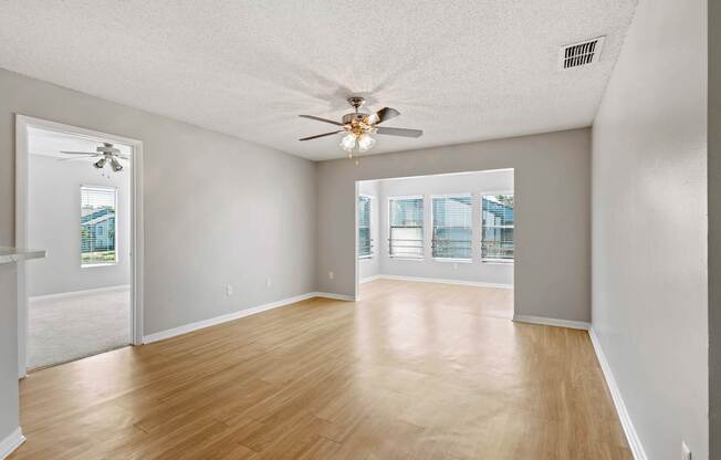 Model living room with wood flooring and ceiling fan at Huntington Place in Sarasota, Florida.