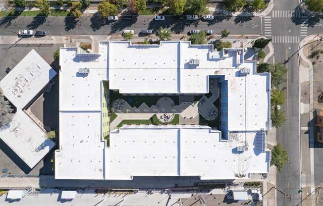 an aerial view of the roof of a white building with a green roof